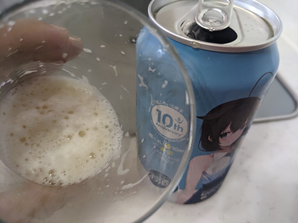 「艦これ10周年お祝い麦酒ペールエール」が入ったグラスを傾けているところ