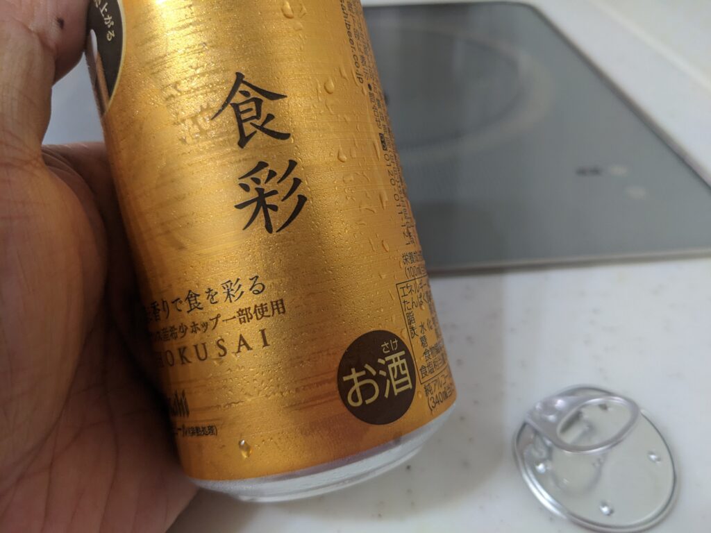 「アサヒ食彩」の缶を傾けているところ