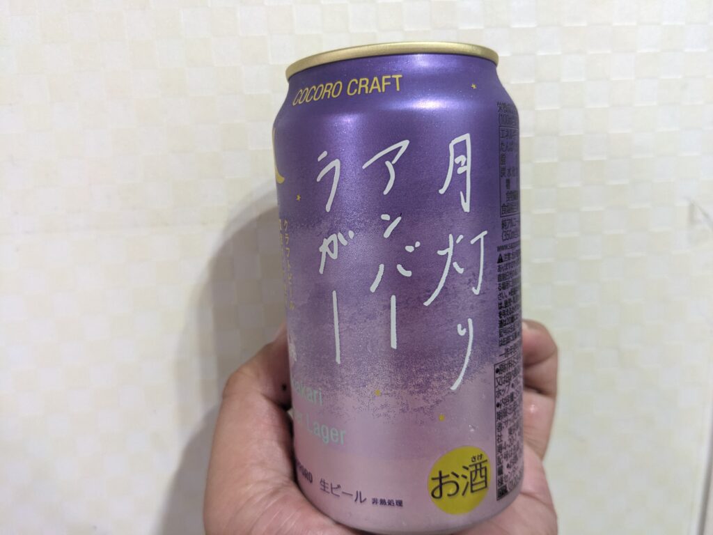 「月灯りアンバーラガー（サッポロココロクラフト）」を手で持っているところ
