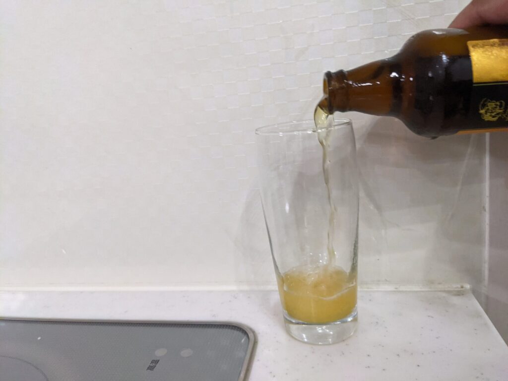 グラスに瓶のエビスマイスターを注ぐ