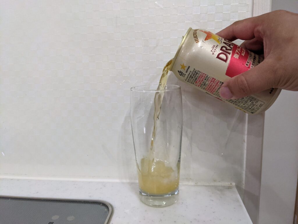 サッポロザ・ドラフティをコップに注いでいる