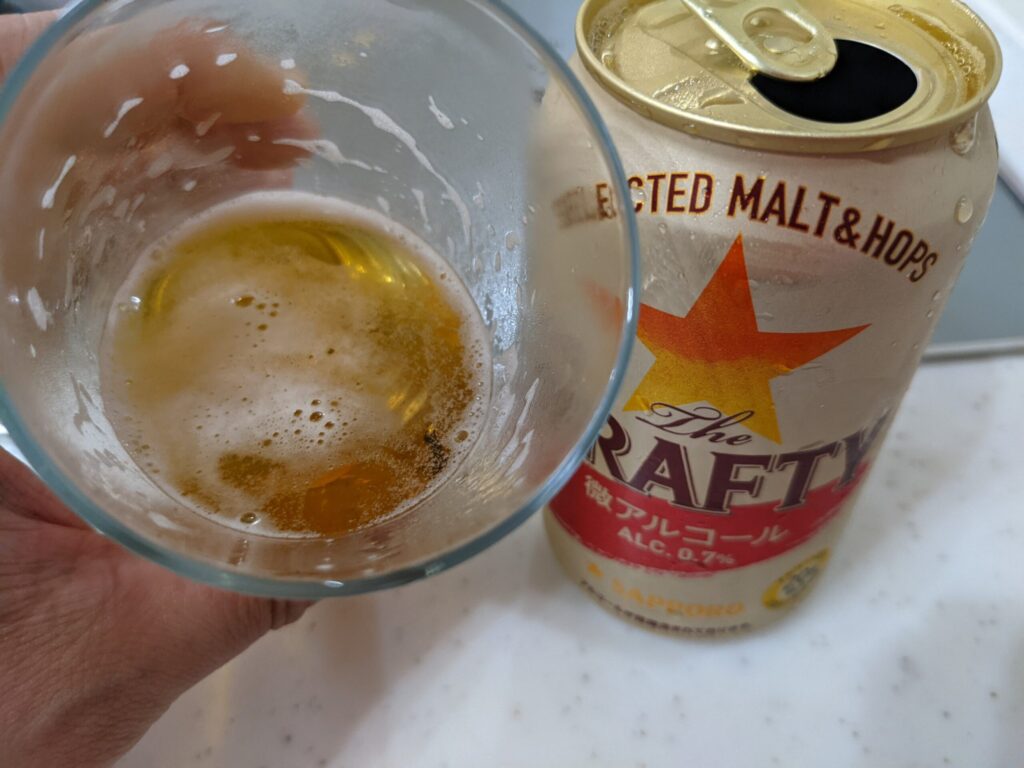 サッポロザ・ドラフティが入ったコップを傾けているところ