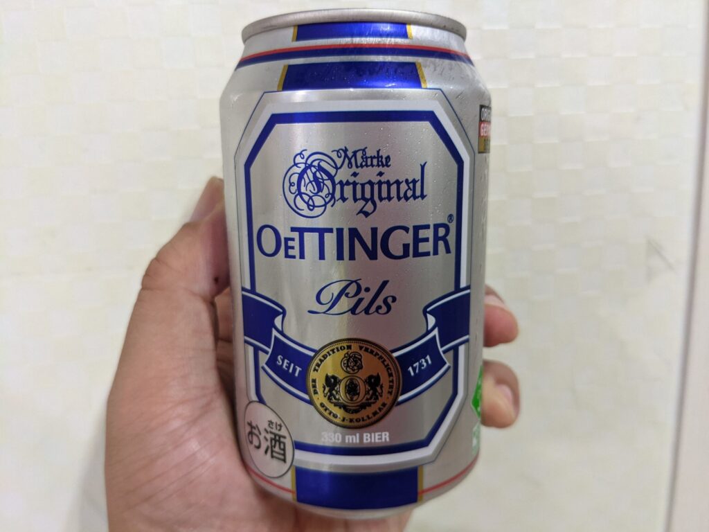 エッティンガー・ピルスの缶を手で持っている