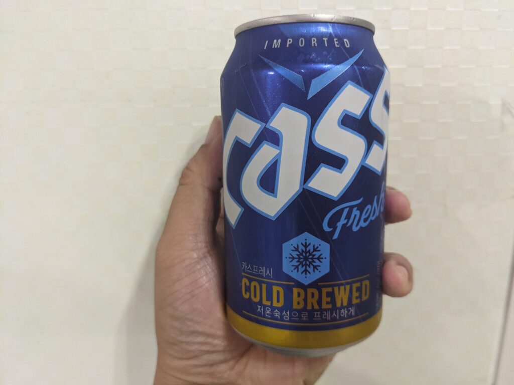 cass（カス）フレッシュビールを手で持っている