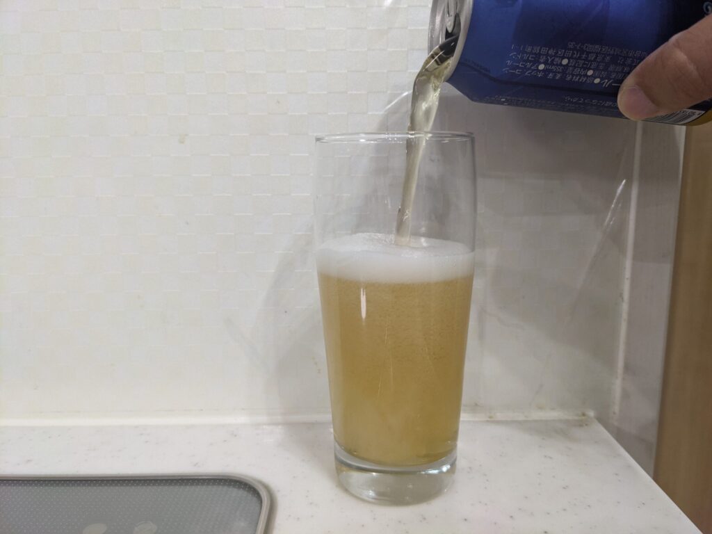 グラス半分程cass（カス）フレッシュビールを注いでいる