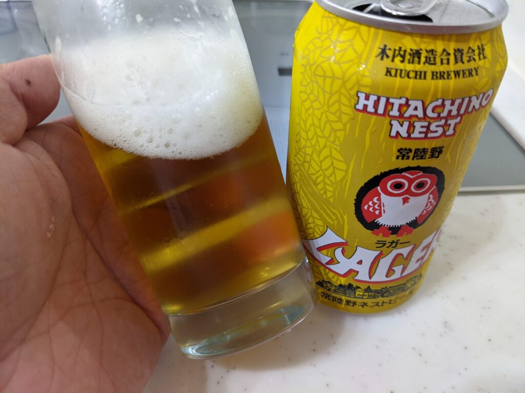 グラスに入った常陸野ネストビールラガーを傾けている