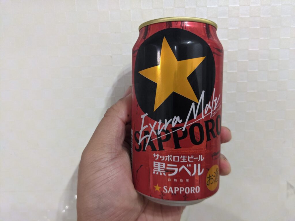「黒ラベルエクストラモルト」を手で持っている