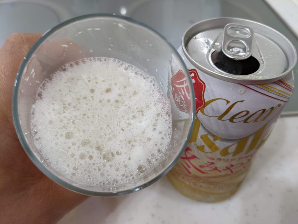 グラスの「クリアアサヒ冬みやび」を飲むところ