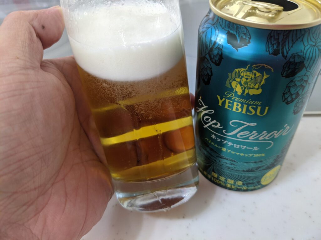 ヱビスホップテロワールが入っているグラスを傾けている