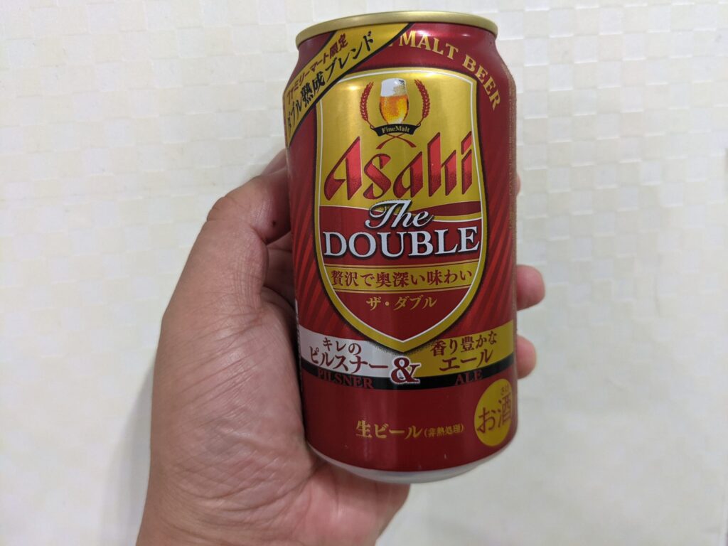 「アサヒ ザ・ダブル」を手で持っている