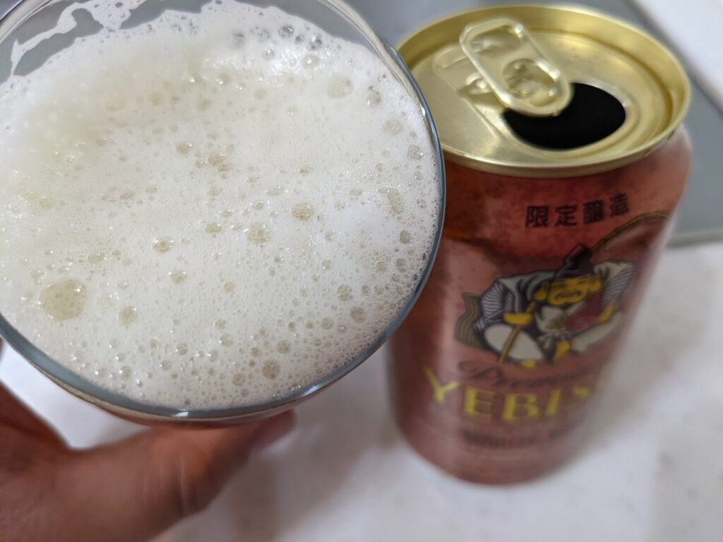 グラスに注がれた「ヱビスウィンターボック」を飲むところ