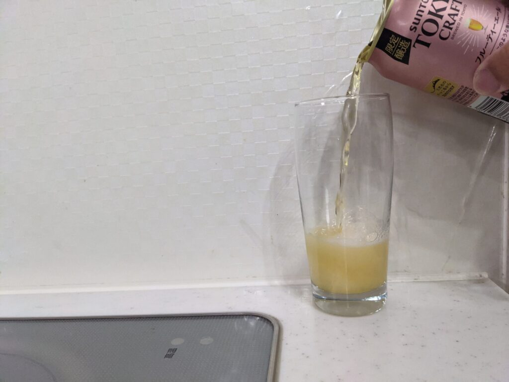 グラスに缶の「東京クラフトフルーティーエール」を注ぐ