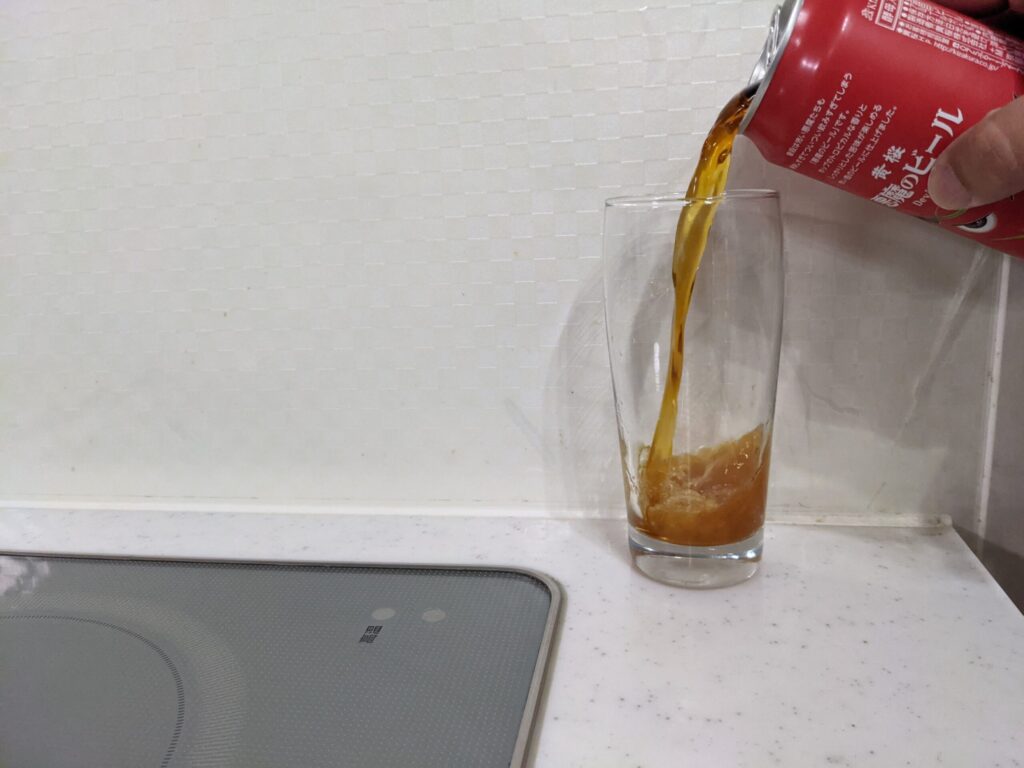 グラスに缶の「悪魔のビールレッドセッションIPA」を注ぐ
