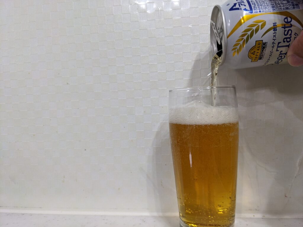 グラス9割程までトップバリュ「Beer Taste（ビアテイスト）」を注いでいる