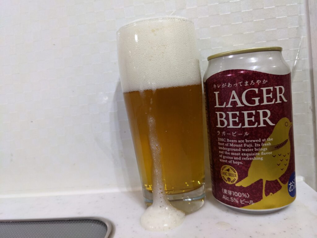 グラスから溢れた「DHCラガービール」とその缶