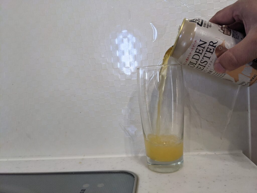 グラスに缶の「DHCゴールデンマイスター（無濾過）」を注いでいるところ