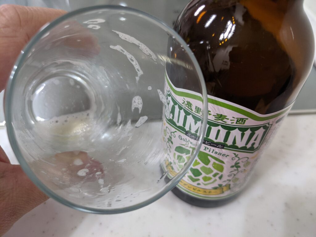 「ズモナビールゴールデンピルスナー」を飲み終えたグラスを手で持っている