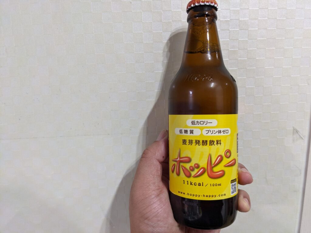 「ホッピー」を手で持っている