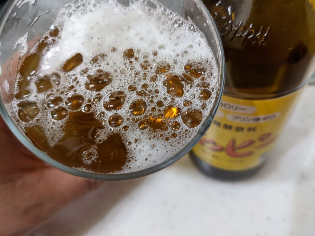 グラスに入った「ホッピー」を飲むところ