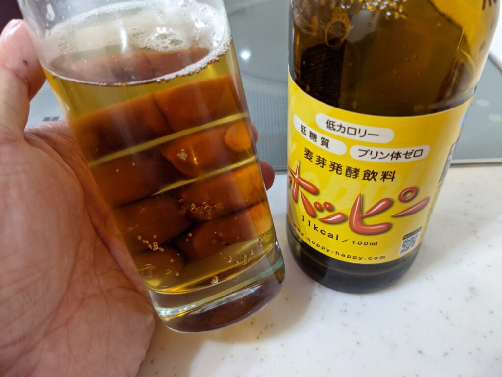 グラスに入った「ホッピー」を傾けているところ