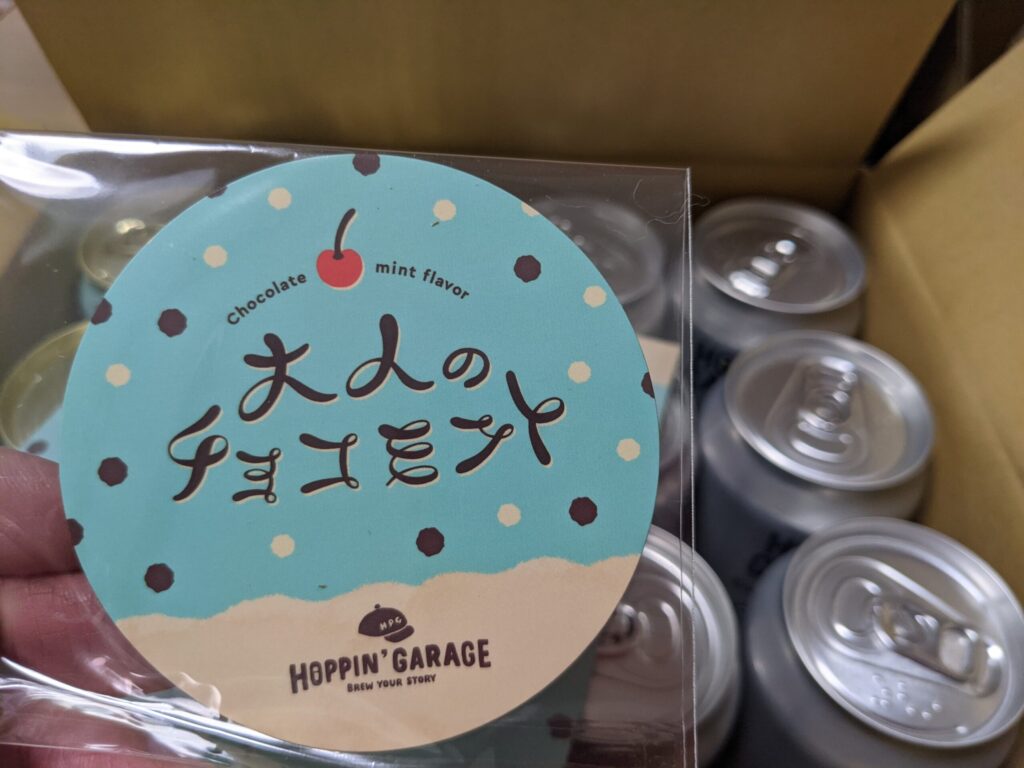 大人のチョコミントビールのマグネットステッカーを手で持っているところ