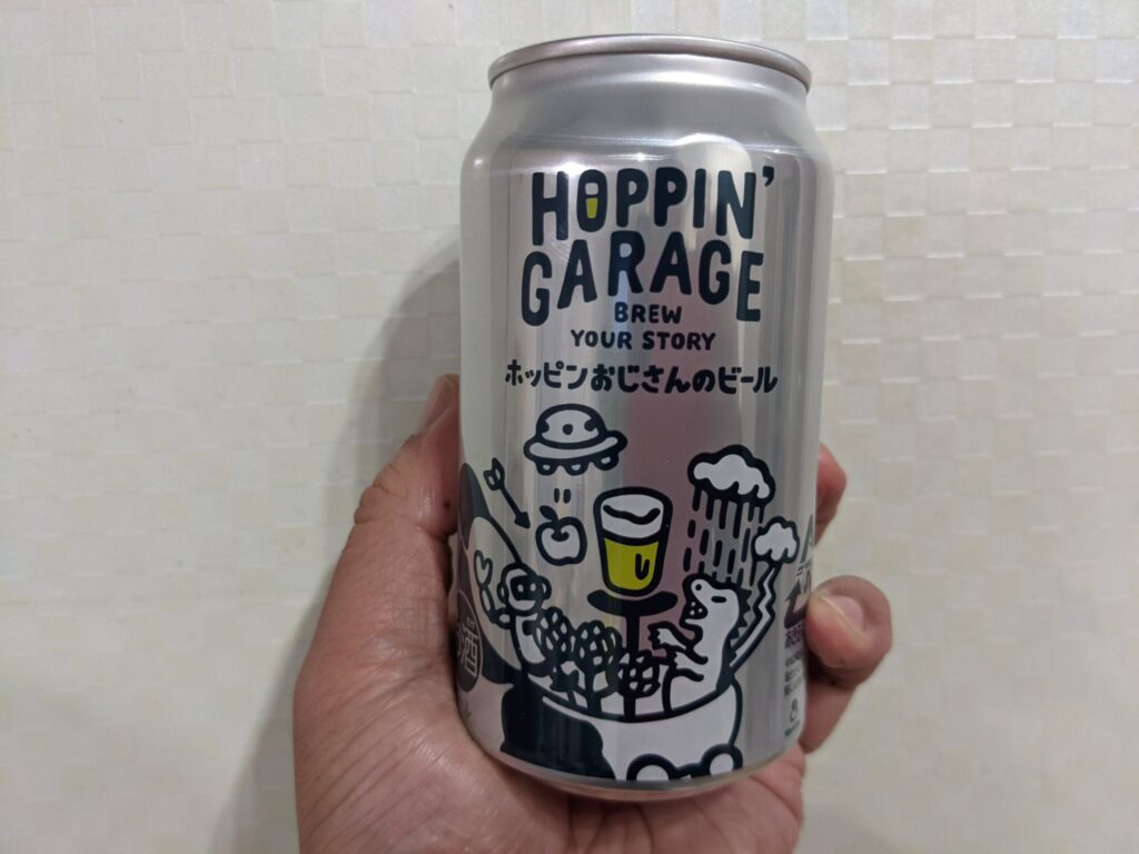 「ホッピンおじさんのビール」を手で持っている