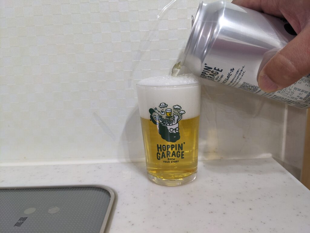 グラスいっぱいに「ホッピンおじさんのビール」を注いでいるところ