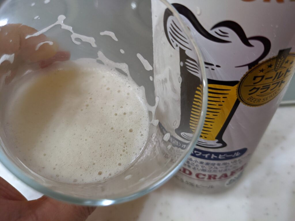 残り半分程のグラスに入った「ワールドクラフト無濾過ホワイトビール」