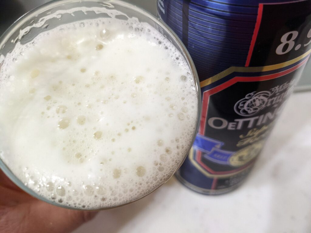 グラスに注がれた「エッティンガースーパーストロング」を飲むところ