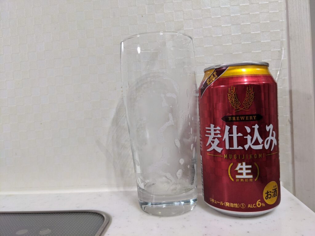 「麦仕込み（生）」が飲み終わったグラスとその空き缶