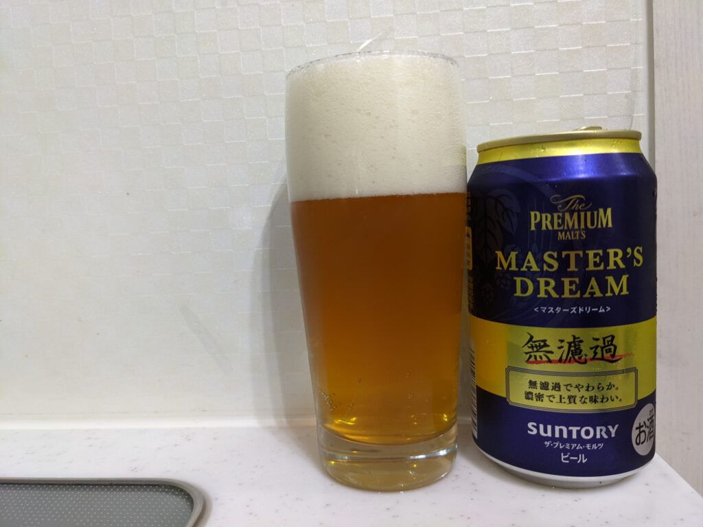 グラスいっぱいに注がれた「マスターズドリーム無濾過」とその缶