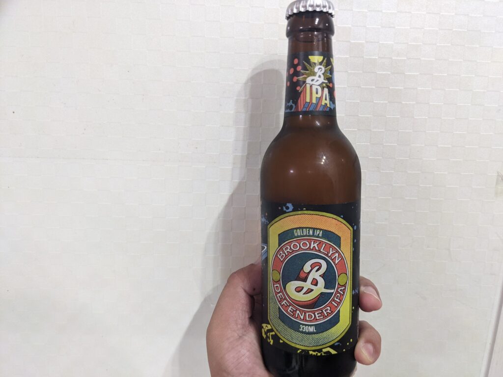 「ブルックリンディフェンダーIPA」を手で持っているところ