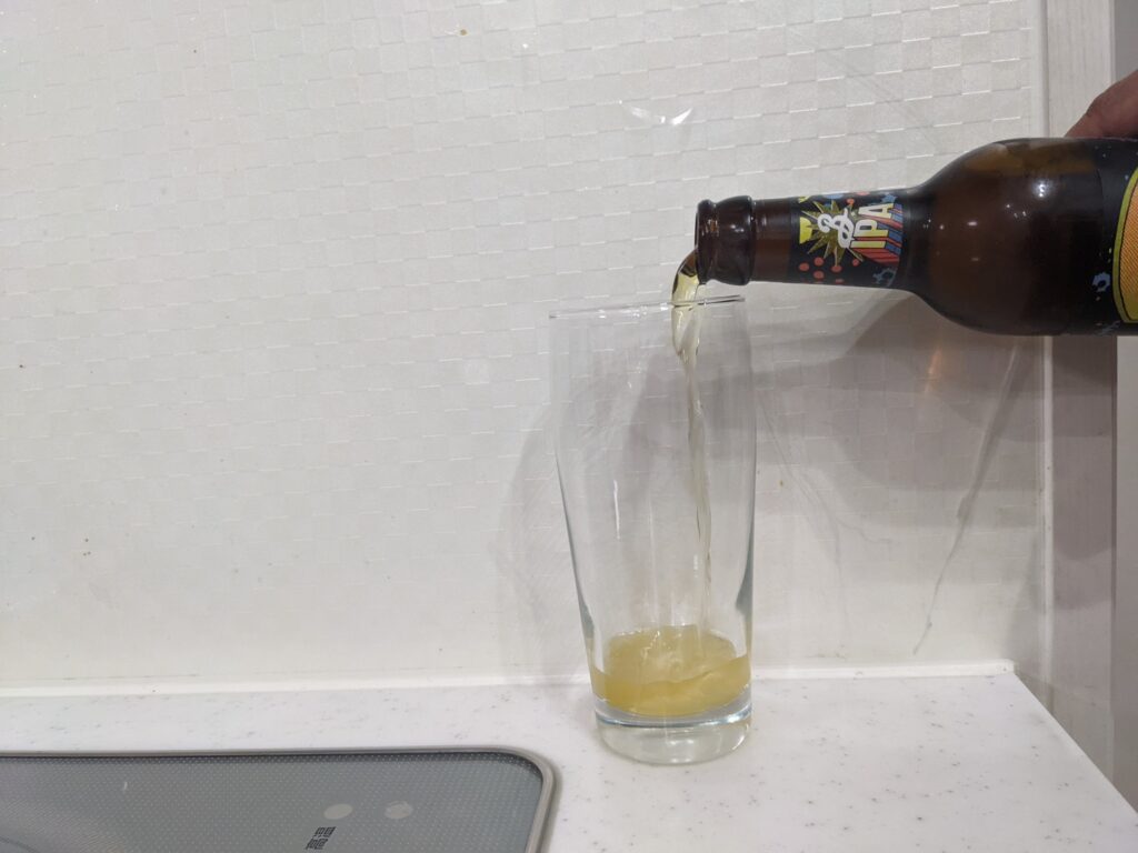 グラスに瓶の「ブルックリンディフェンダーIPA」を注いだところ