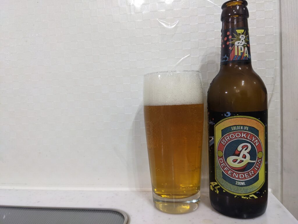 グラスに注がれた「ブルックリンディフェンダーIPA」とその瓶