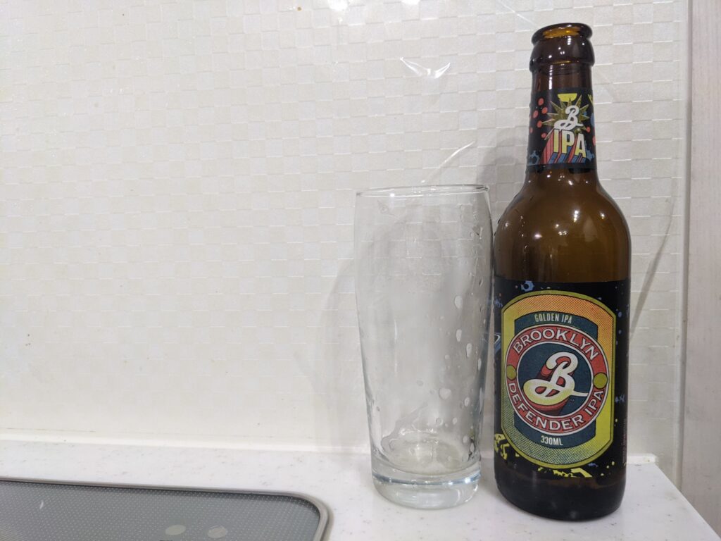 「ブルックリンディフェンダーIPA」が飲み終えたグラスとその空き瓶