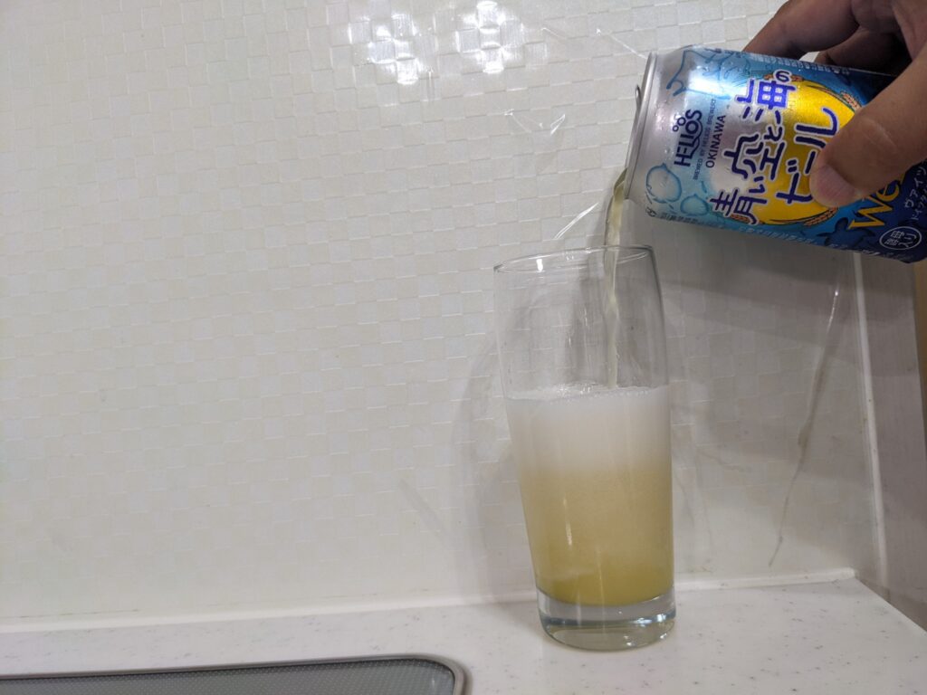 グラスに缶の「青い空と海のビール」を半分程注いだところ