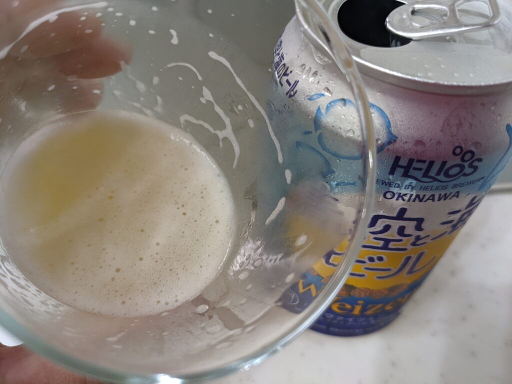 グラスに残り半分程入った「青い空と海のビール」