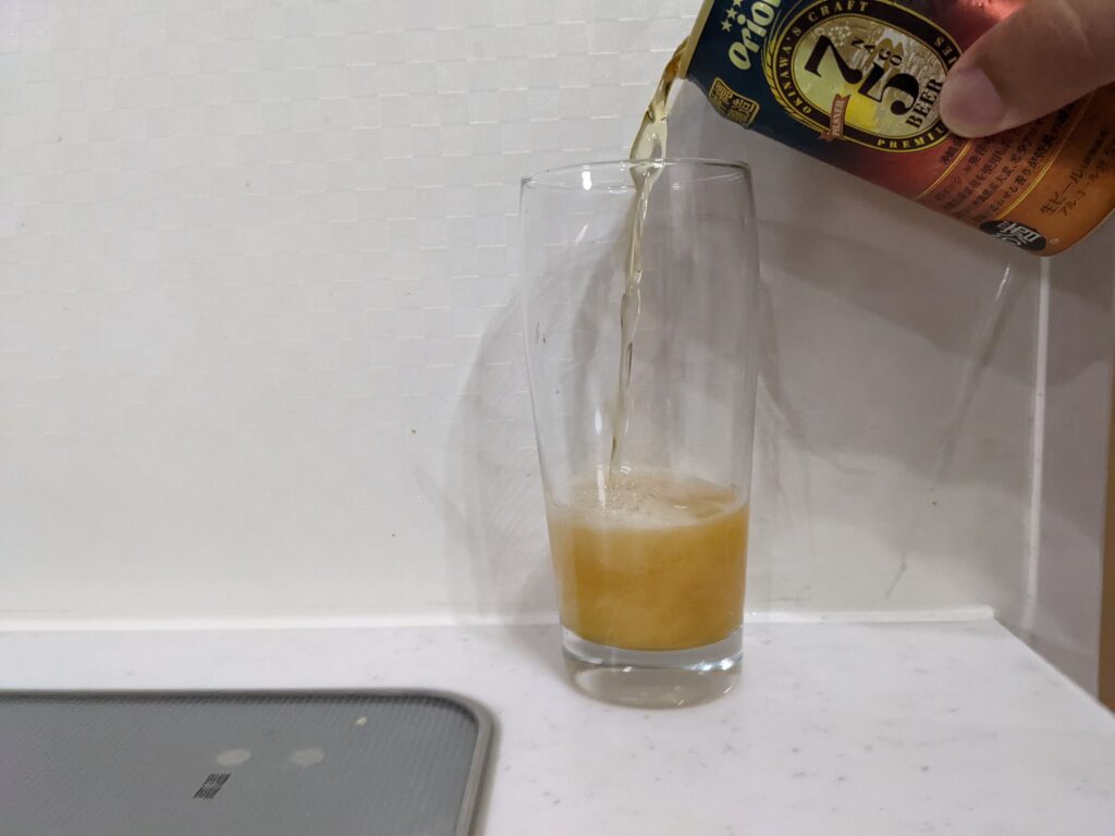 グラスに缶の「75（名護）ビールピスルナー」を注いだところ