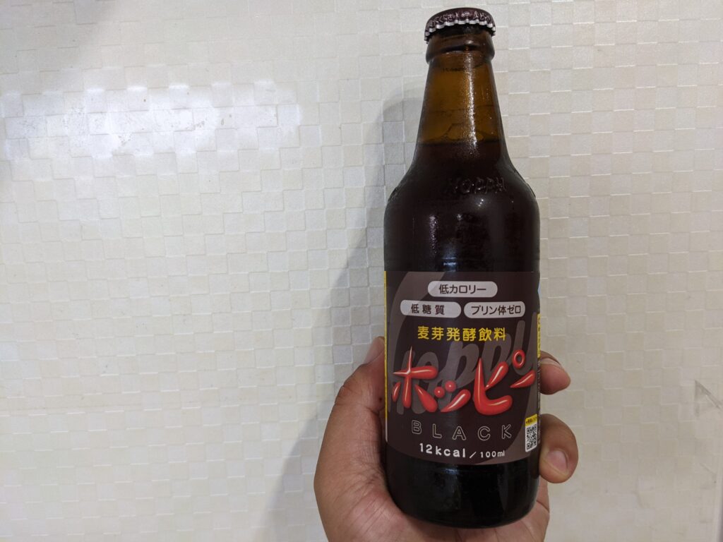 黒ホッピー（ホッピーブラック）を手で持っている