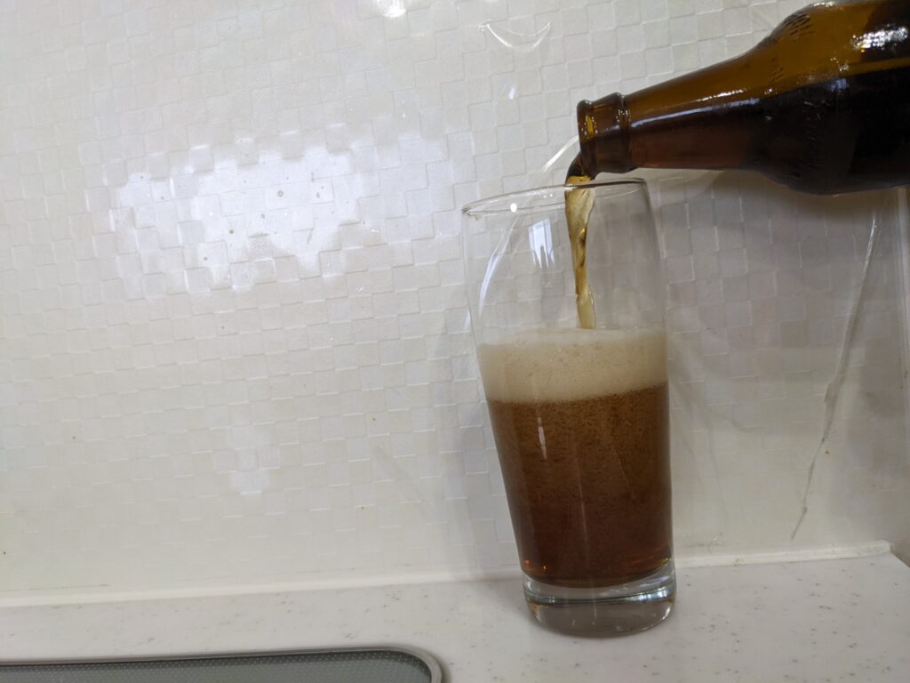 黒ホッピーを勢いよく注いでいるところ