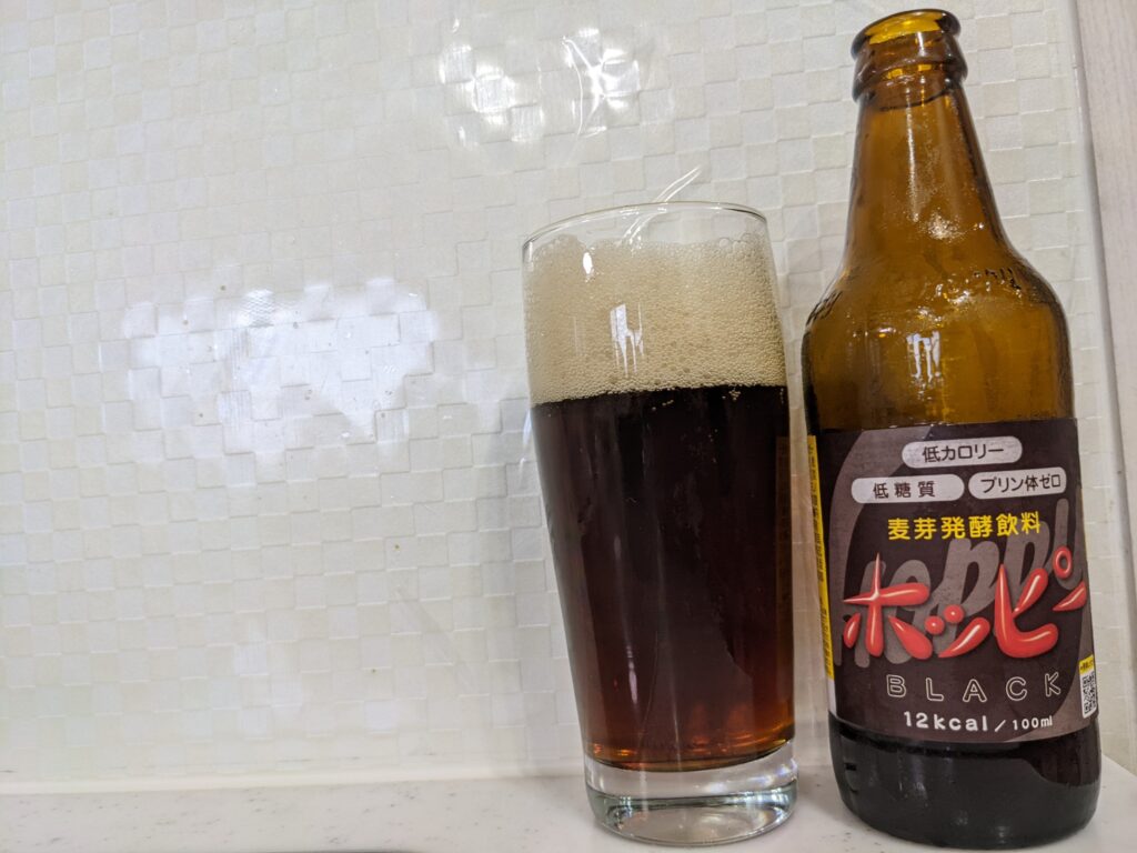 黒ホッピー（ホッピーブラック）が注がれたグラスとその瓶