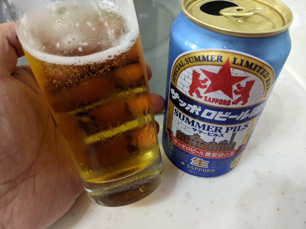 「サマーピルス（サッポロビール園）」が入ったグラスを傾けているところ