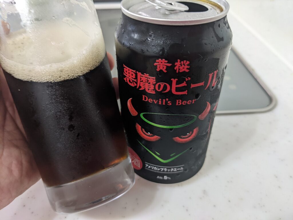 「悪魔のビール【黒】アメリカンブラックエール」が入ったグラスを傾けているところ
