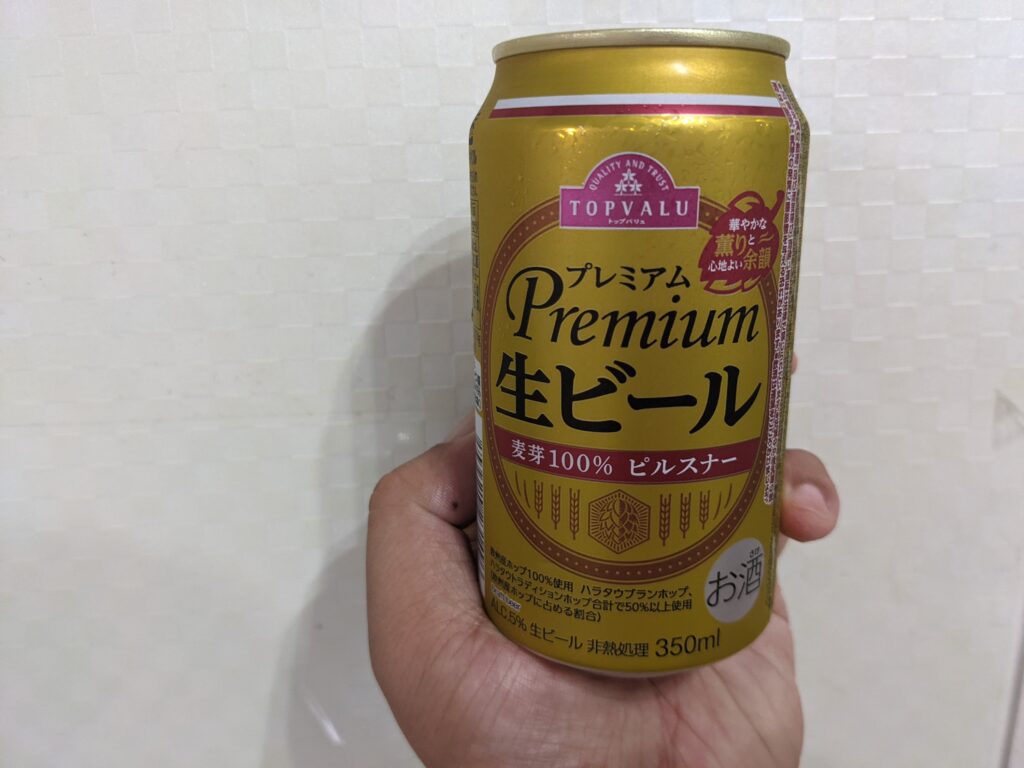 「トップバリュ」プレミアム生ビールを手で持っているところ