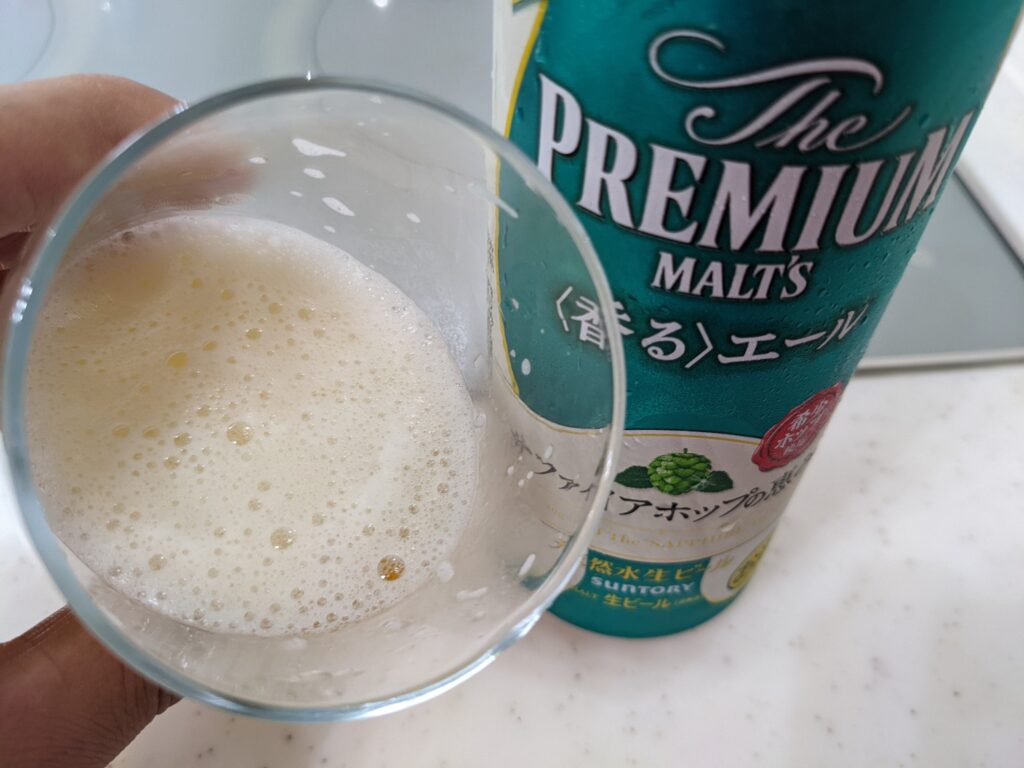 「サファイアホップの恵み（プレモル香るエール）」が入ったグラスを手前に傾けたところ