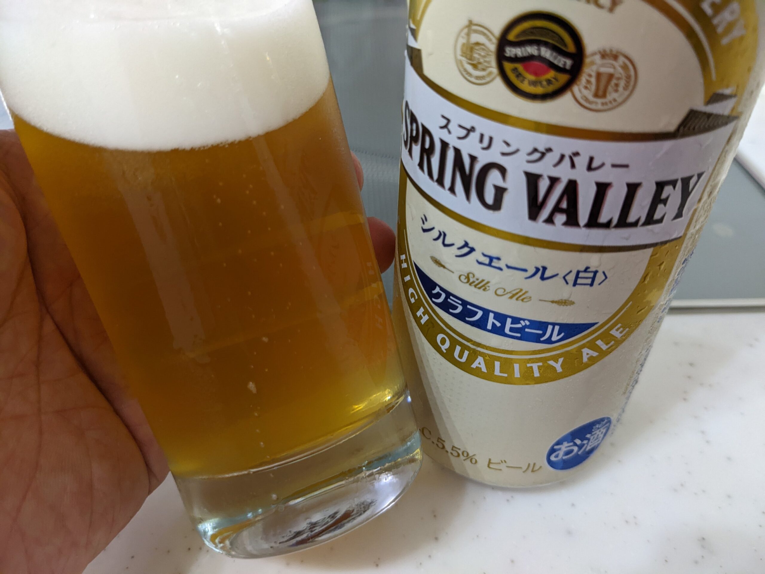 「シルクエール白（スプリングバレー）」が入ったグラスを傾けているところ