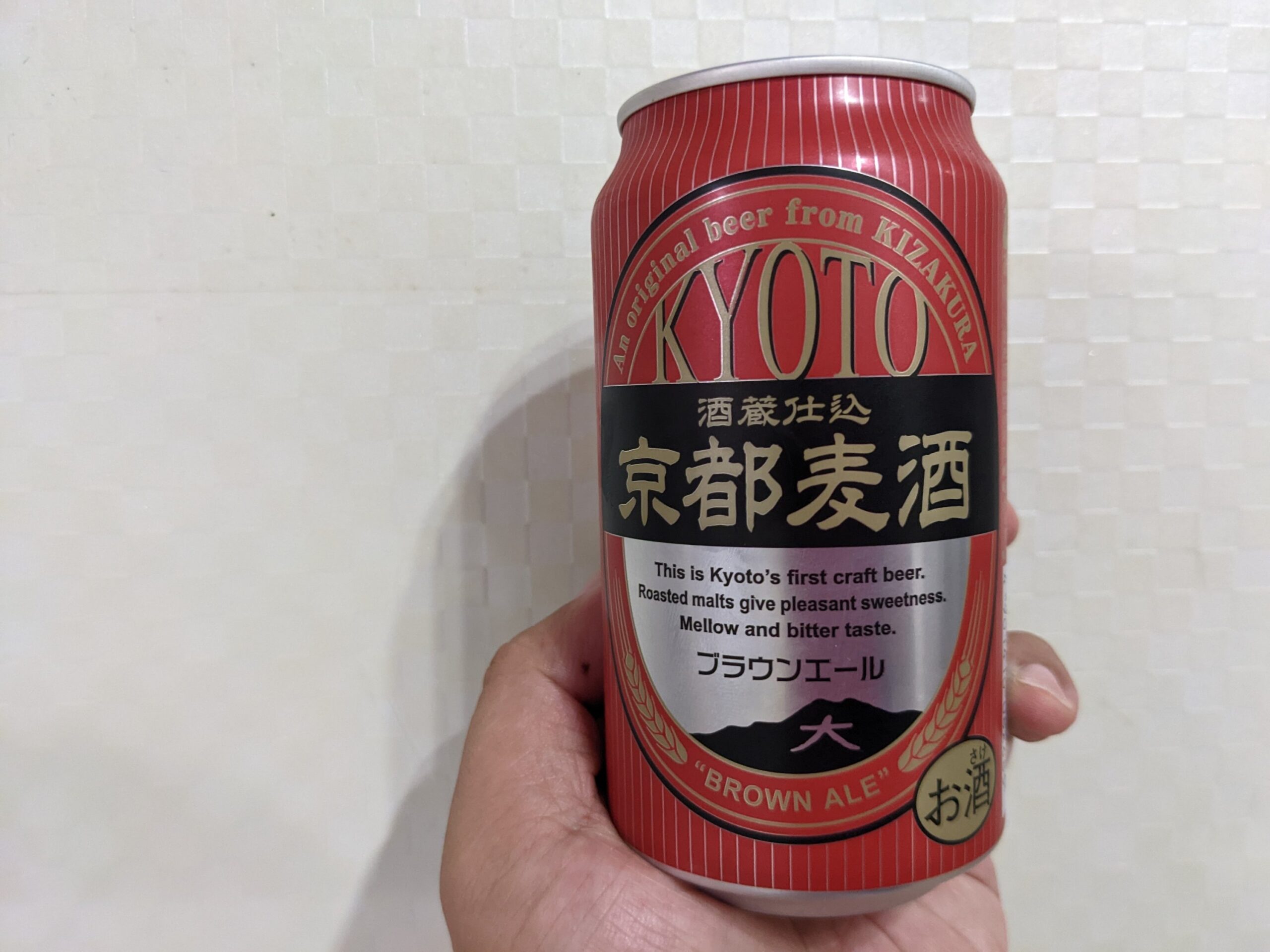 「京都麦酒ブラウンエール 」を手で持っているところ