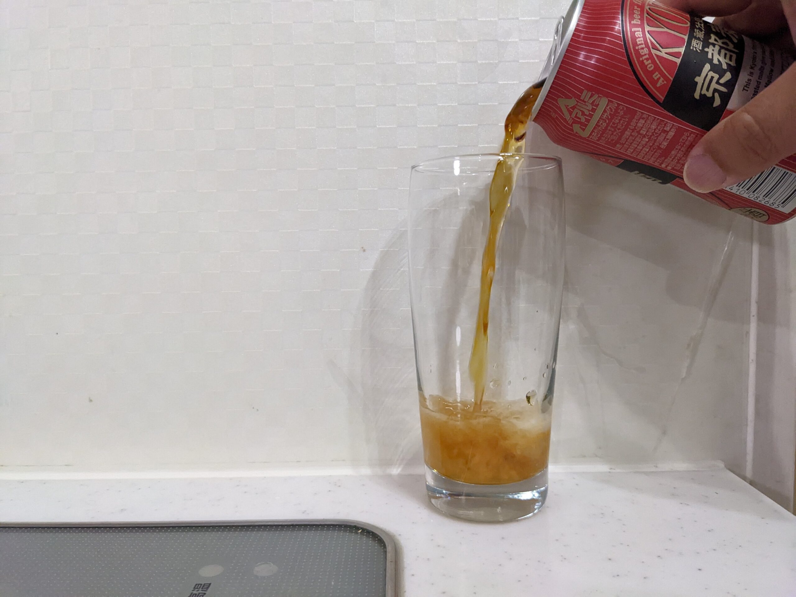 グラスに缶の「京都麦酒ブラウンエール 」を注いだところ