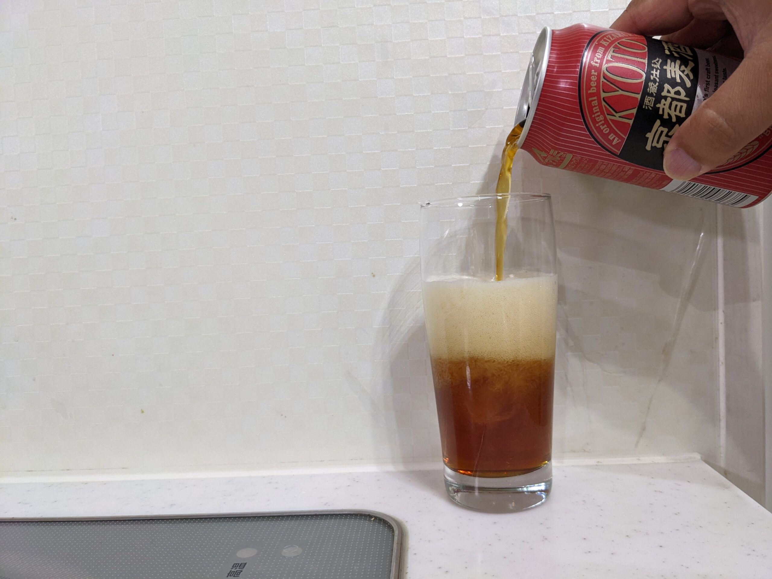 グラスに缶の「京都麦酒ブラウンエール 」を6割程注いだところ