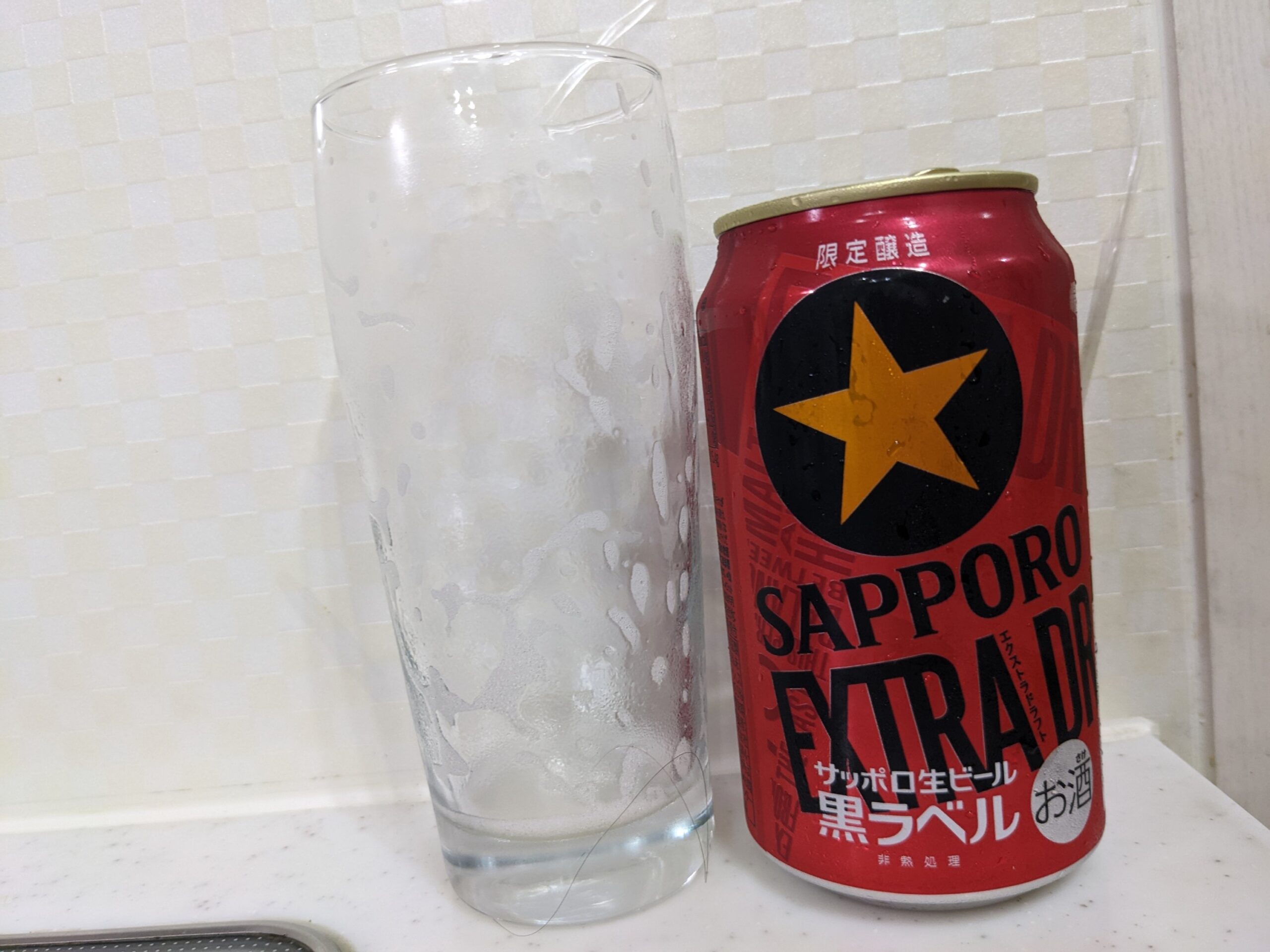 「黒ラベルエクストラドラフト」を飲み終えたグラスとその空き缶